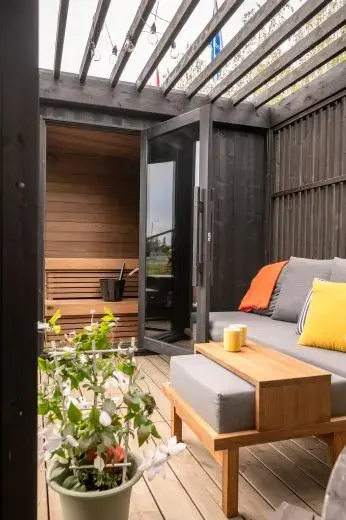 Kirami FinVision® -pergola Misty, decorate con un divano.